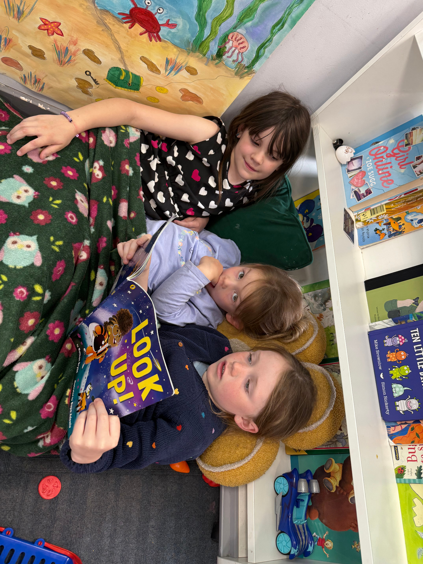 Children sharing a story together in a cosy reading corner at AllSorts