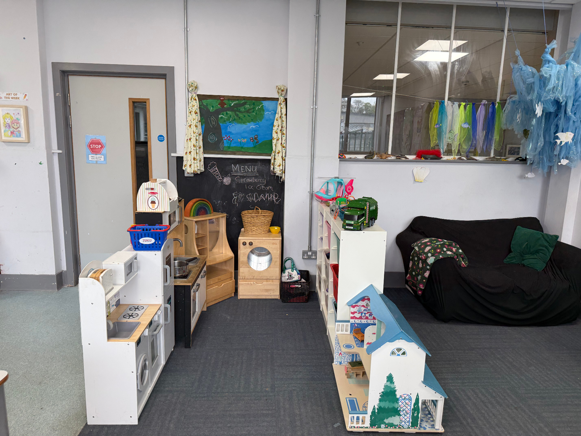 Role play area with toy kitchen, dollhouse and reading sofa